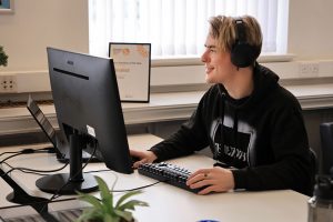 Employee working in a calm environment using headphones as a reasonable adjustment to improve focus